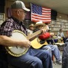 Country musicians playing old time music in a music store with an american flag